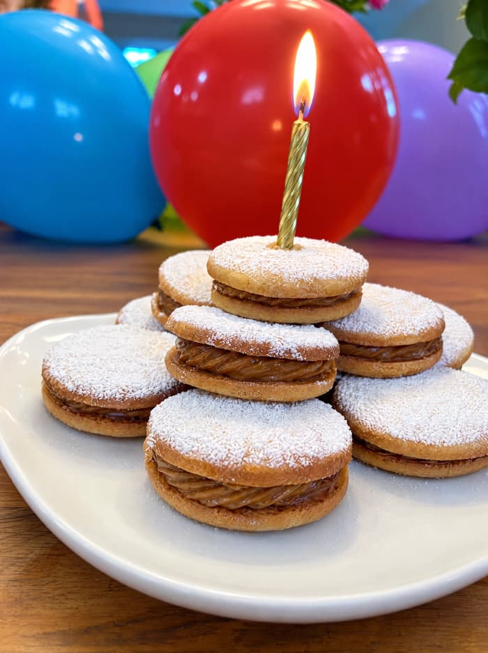 A candle-lit stack of alfajores for a birthday celebration