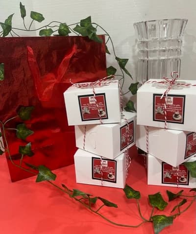 Boxes of cookies stacked with a red gift bag