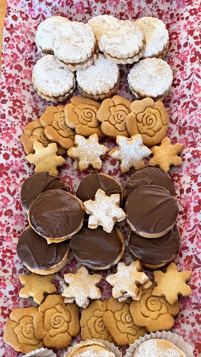 An assorted platter of alfajores, including rose and star shortbread and chocolate-dipped cookies